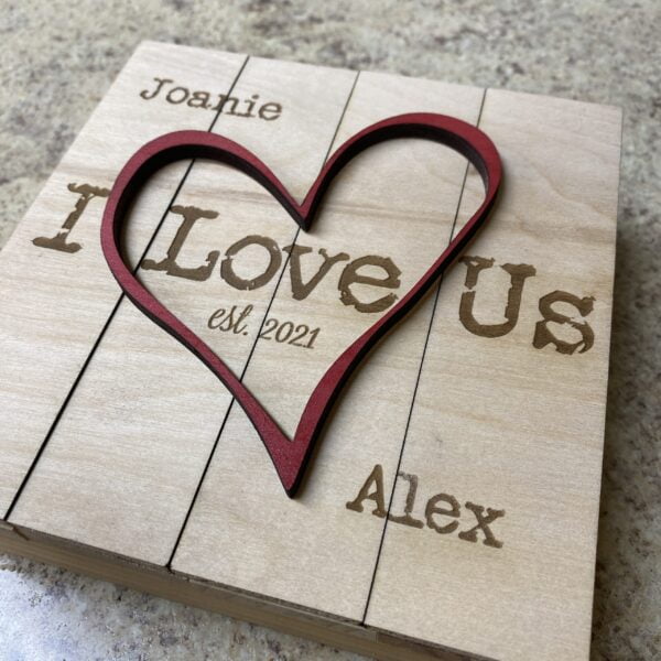 i love us, a heart carved into a wood plaque